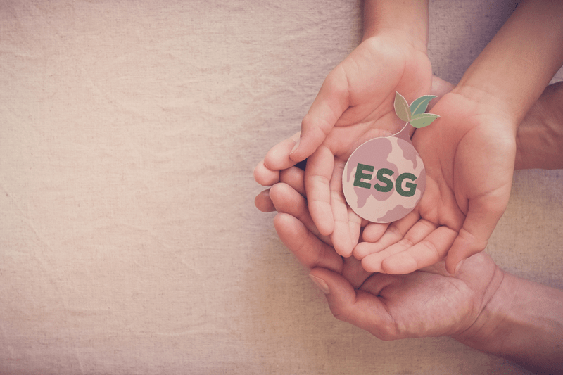 Hands holding a seed shaped like earth with ESG label