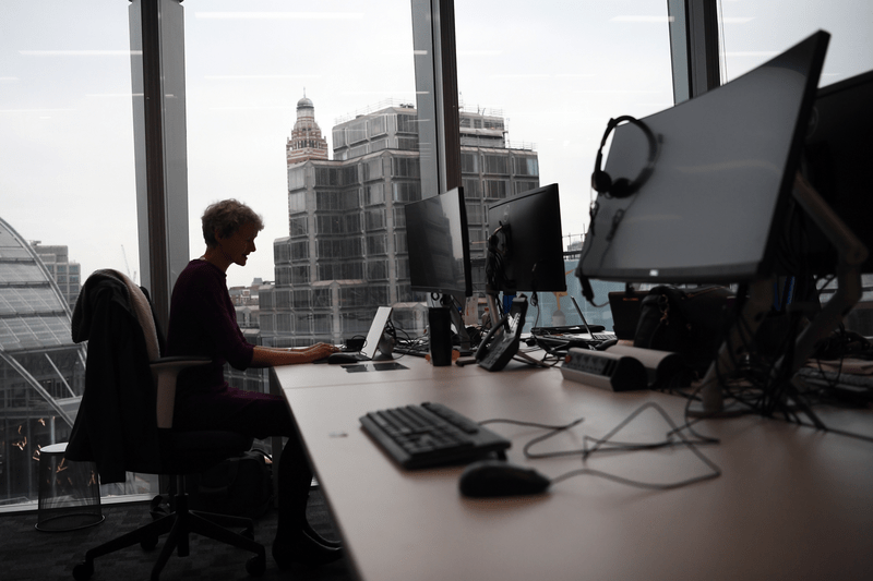 A person is sitting in an office by a window.