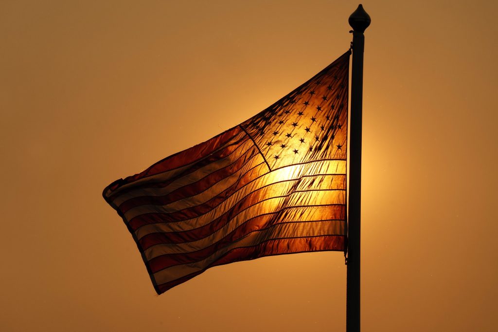 US flag against sunrise