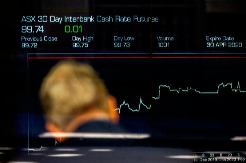 A man is seen in front of the electronic display of stocks at the Australian Stock Exchange