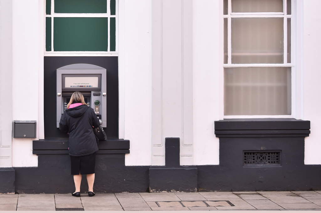 A lady withdraws cash from an ATM