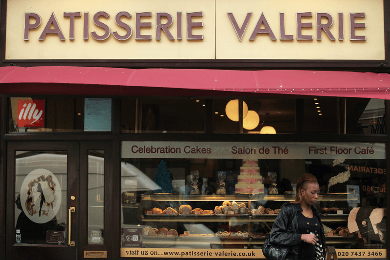 A woman walks past Patisserie Valerie in the Soho area of the City of Westminster