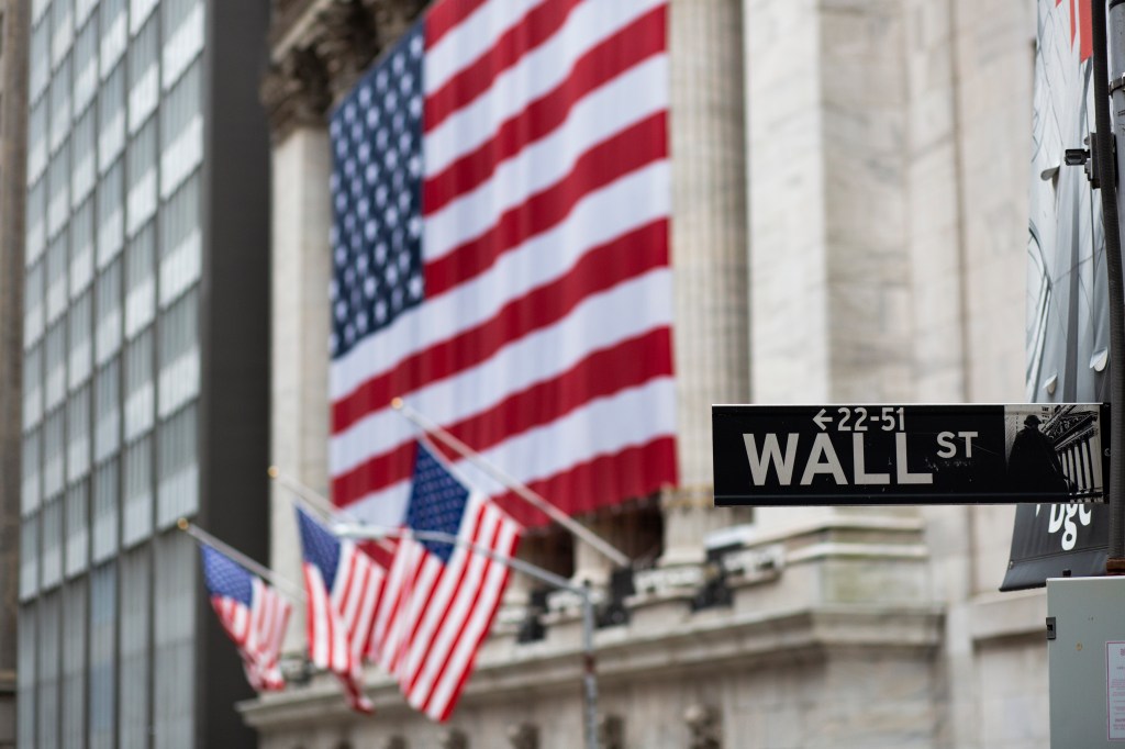 Image of Wall Street sign and American flags.