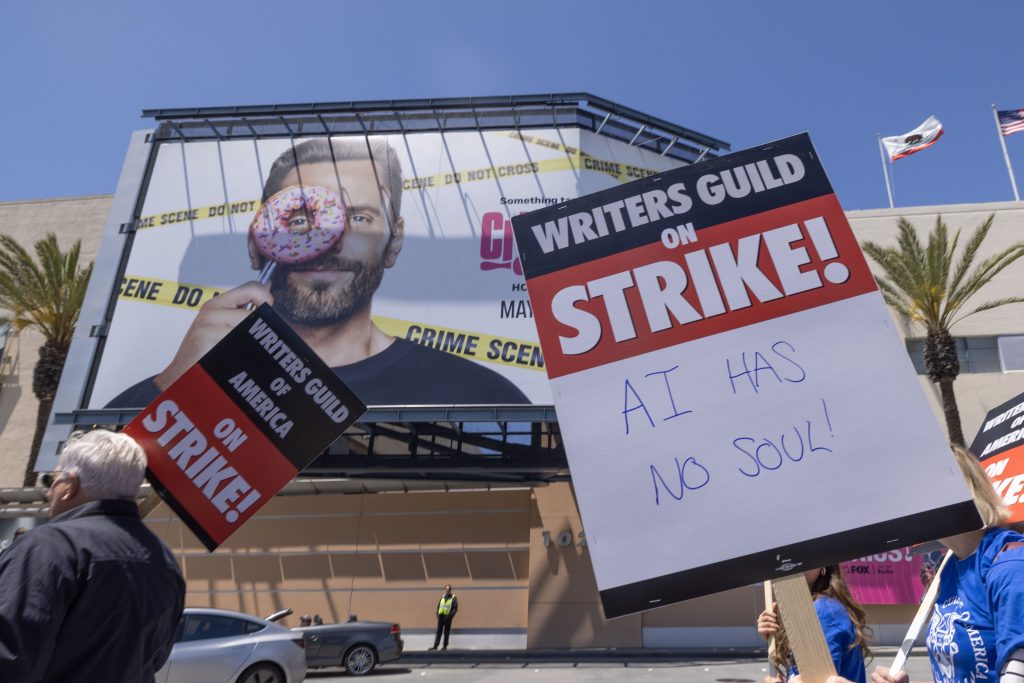 Image of a woman protesting and holding a sign reading "AI has no soul"