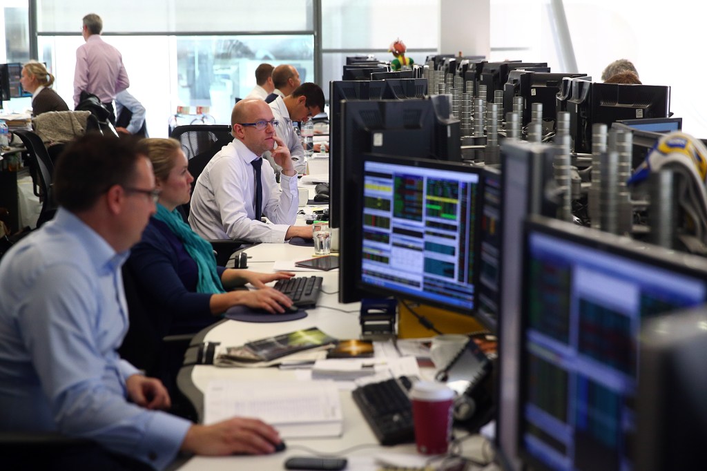 Office staff at bank of screens