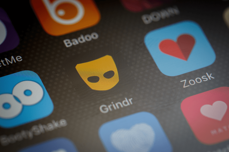 The "Grindr" app logo is seen amongst other dating apps on a mobile phone.