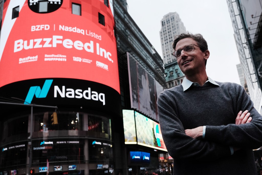 Image of Buzzfeed CEO posing in front of Nasdaq exterior billboard that notes the company going public with shares trading at the exchange.