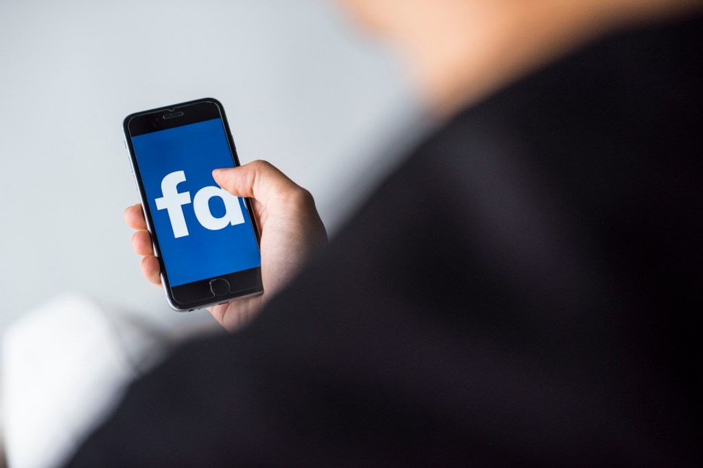 Image of a mobile phone showing the Facebook logo.