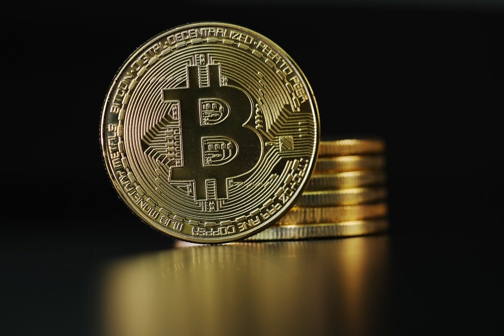 Image of bitcoins stacked up and one of them facing the camera.