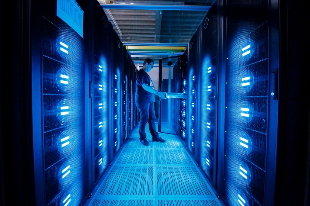 Image of a man checking on a supercomputer network.