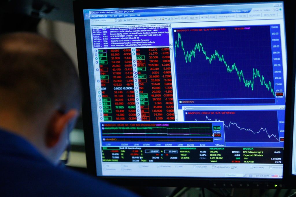A trader next to a monitor of currency charts.