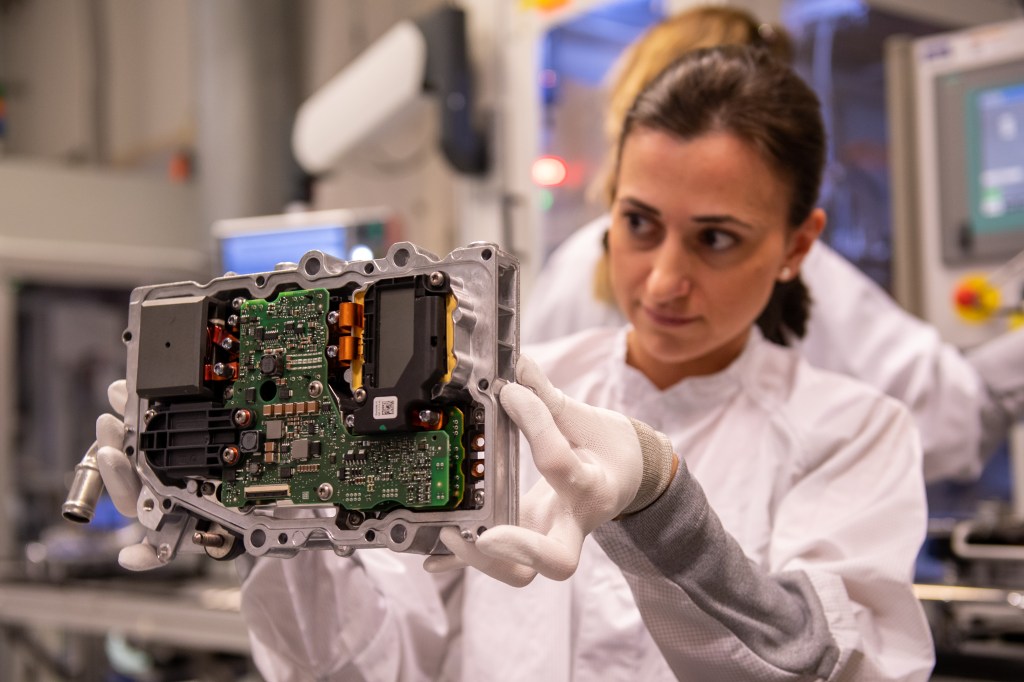 Image of a technician looking at electronic components on a circuit board.