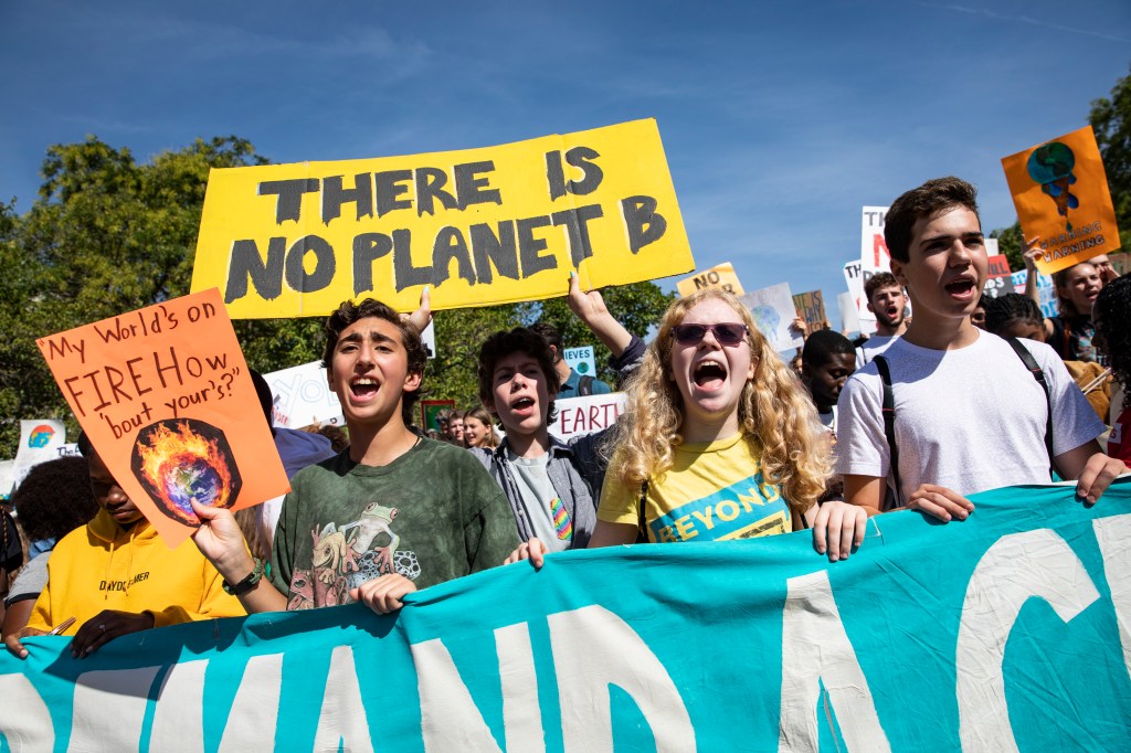 Young adults demonstrating for climate change action from lawmakers.