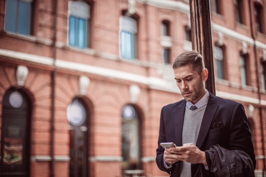 Smartly dressed man using phone