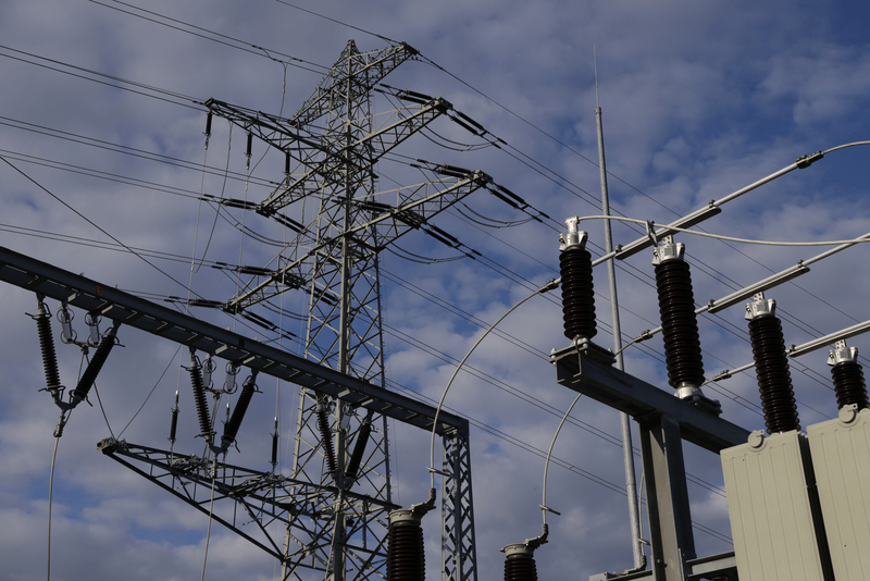 An electric power transmission pylon stands behind a relay station near Teuchern, Germany.