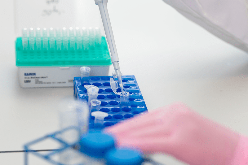 A medical researcher holds a pipette in a medical laboratory.