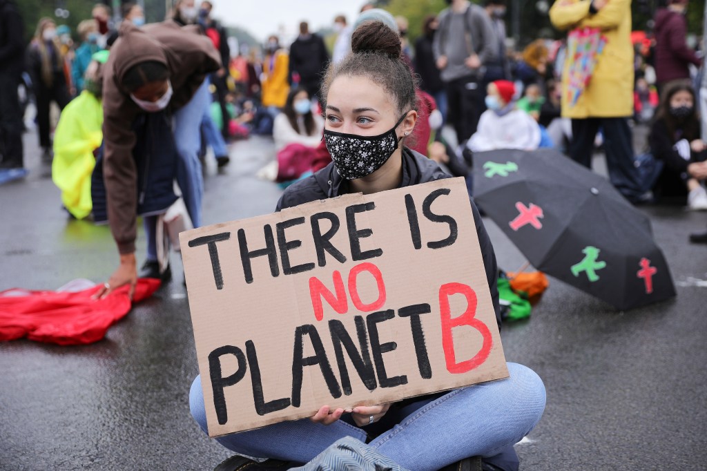 Image of a young woman with a sign saying "There is no Planet B."