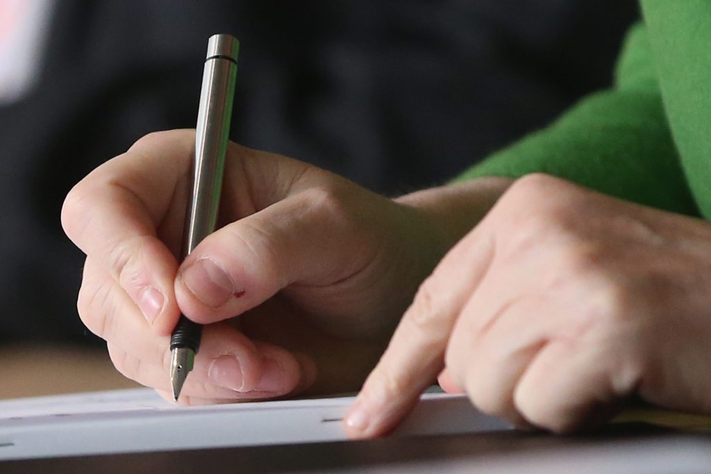 Image of a person signing a document on a tablet.