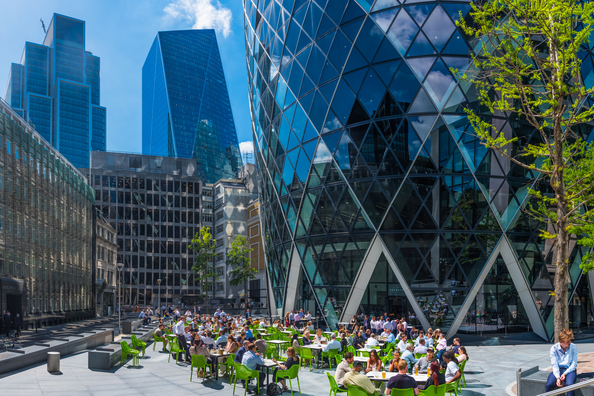 London office workers enjoying sunshine lunchtime below Gherkin City panorama