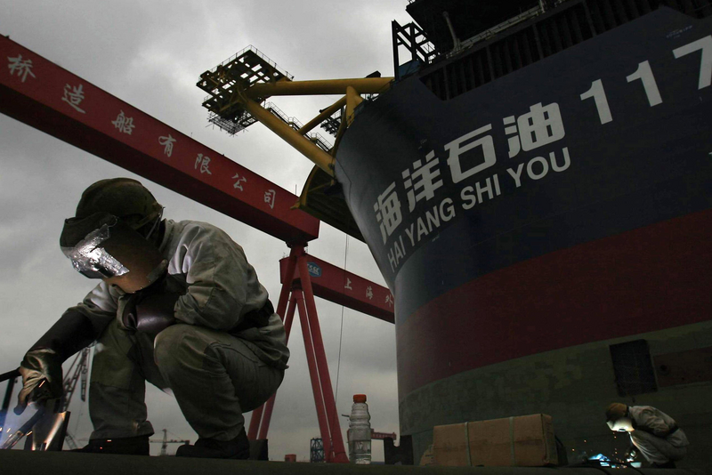 Engineers weld at the dock during the launching ceremony of floating production storage off-loading at Shanghai