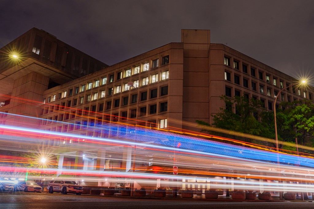 Image of federal buildings in Washington, D.C., with cars whizzing past.