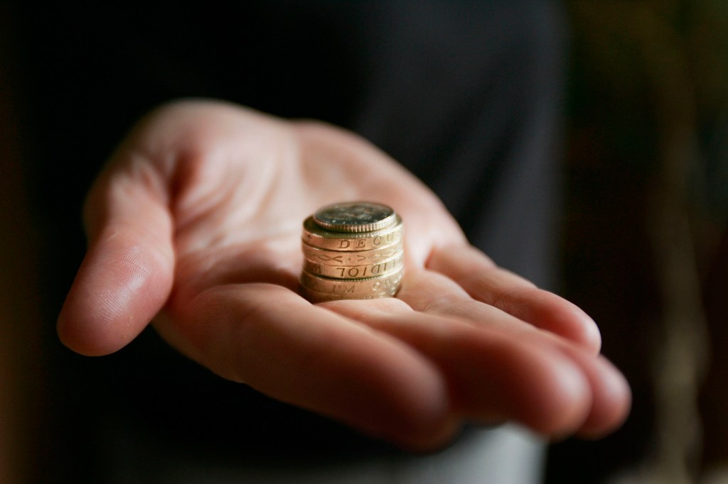Image of an outstretched hand with some coins in it.