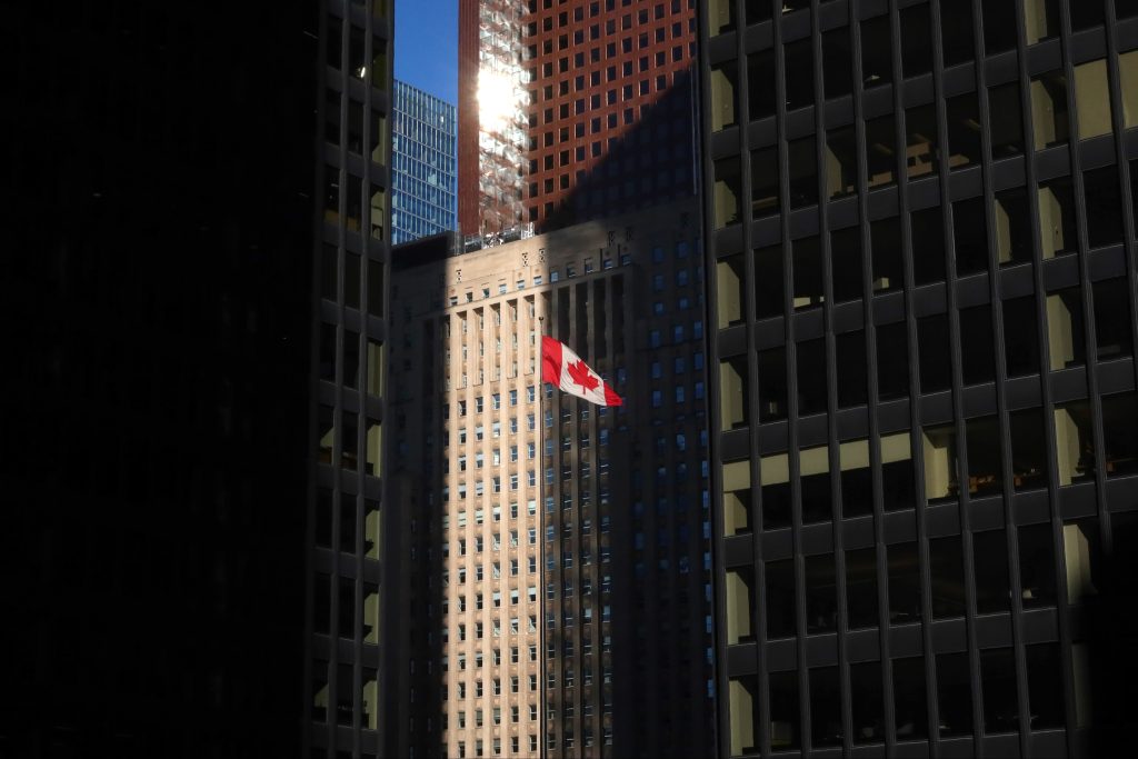 A Canadian flag flies in the financial district between the towers of the Toronto-Dominion Center and the Bank of Nova Scotia tower in Toronto, Canada.