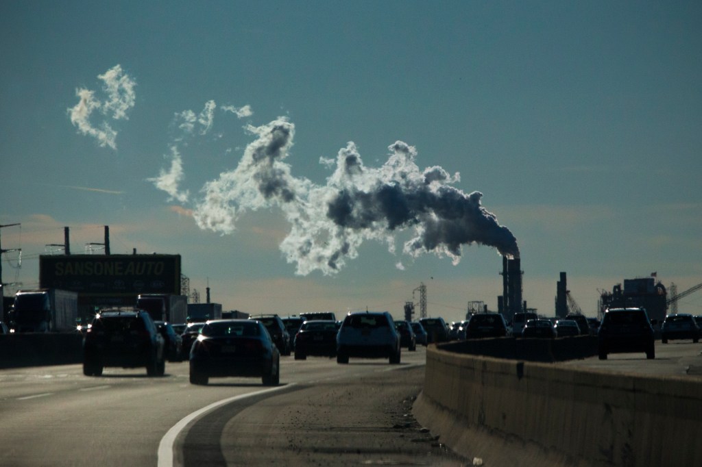 Smoke form chimney and traffic at New Jersey Turnpike.