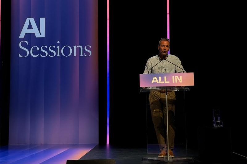 Warren Roy speaking on stage at All In conference