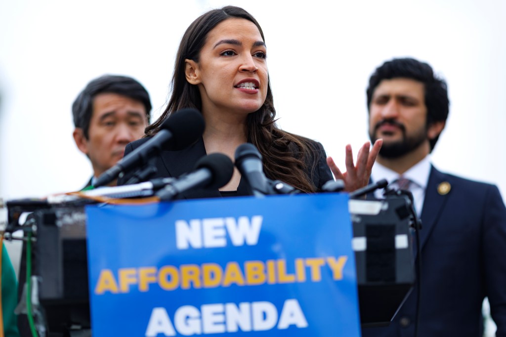 A photo of Rep. Alexandra Ocasio-Cortez speaking outdoors at a podium with a sign that reads "New Affordability Agenda."
