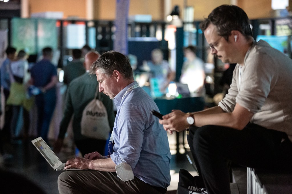 Participants dressed in business casual attire working on laptop, phone at re:publica 22 on June 09, 2022 in Berlin