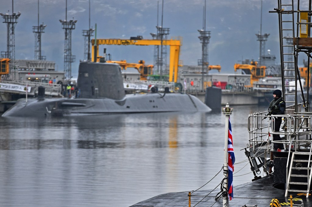Royal Navy security personnel stand guard on HMS Vigilant at His Majesty's Naval Base, Clyde, Scotland.