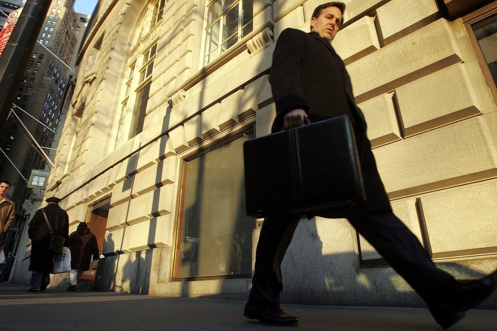 A businessman walks along Broadway in the financial district in New York City.