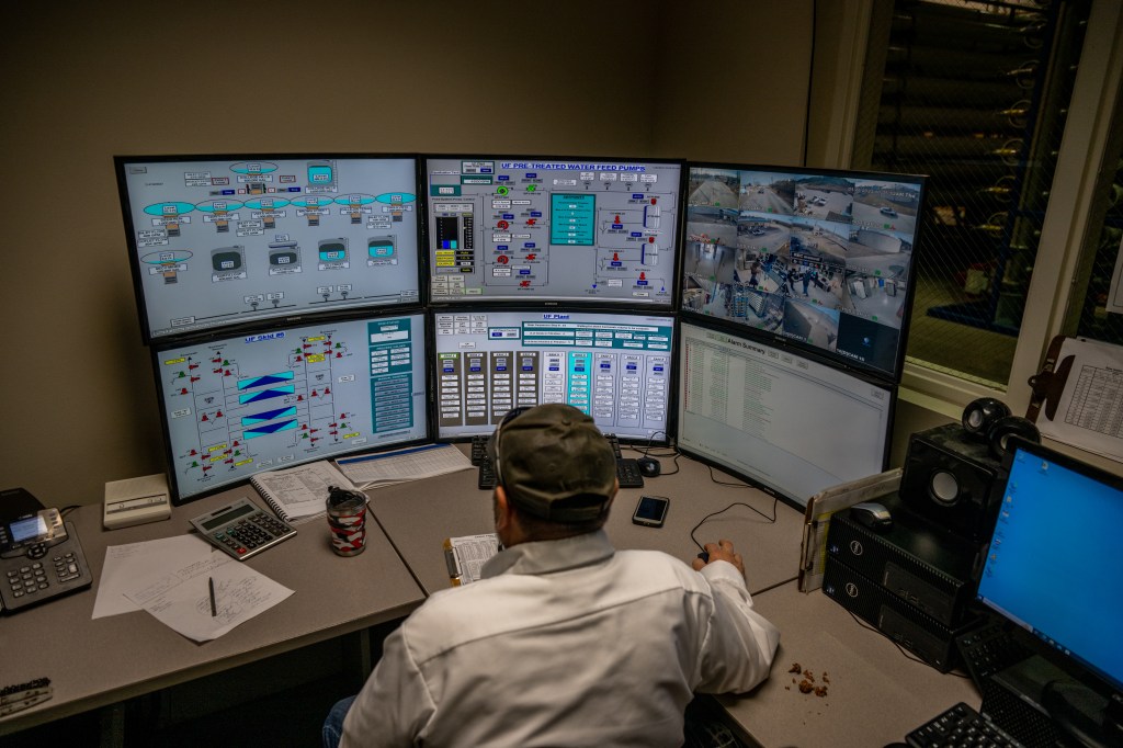 Person sitting in front of control room screens