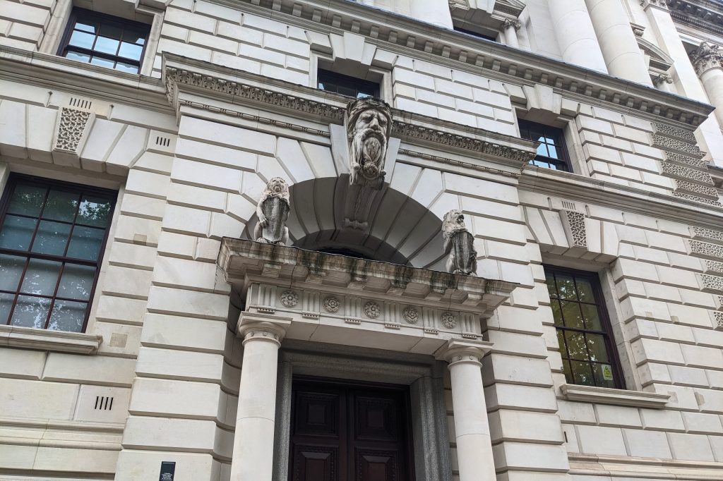 Neoclassical stone carvings and sculptures decorate the main entrance of the HM Treasury building at 1 Horse Guards Road in the historic Whitehall district of the city