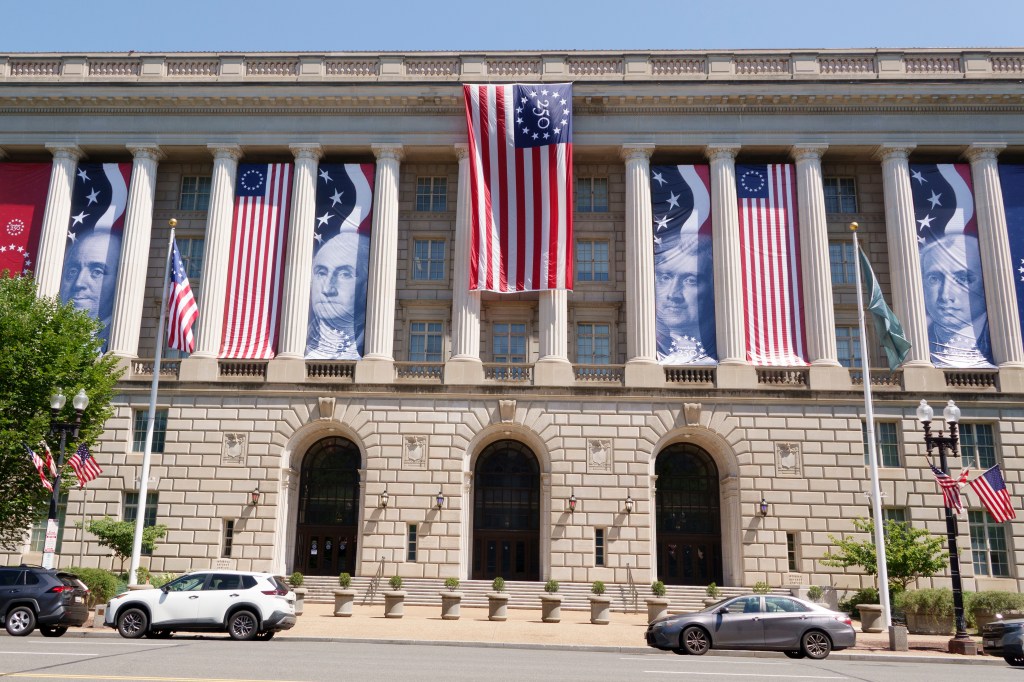 Flags for America's 250th birthday celebration hang at the Internal Revenue Service (IRS) Building on June 4, 2026 in Washington, DC.