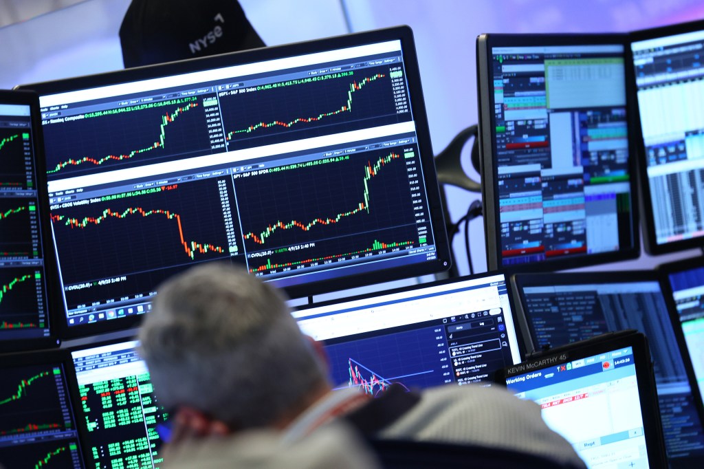 Image of investment trading performance data on computer screens.