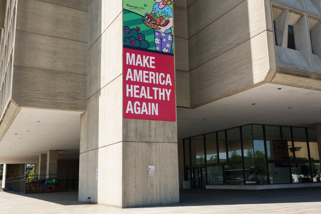 A photo of a concrete building with a red sign on the wall reading "Make America Healthy Again."
