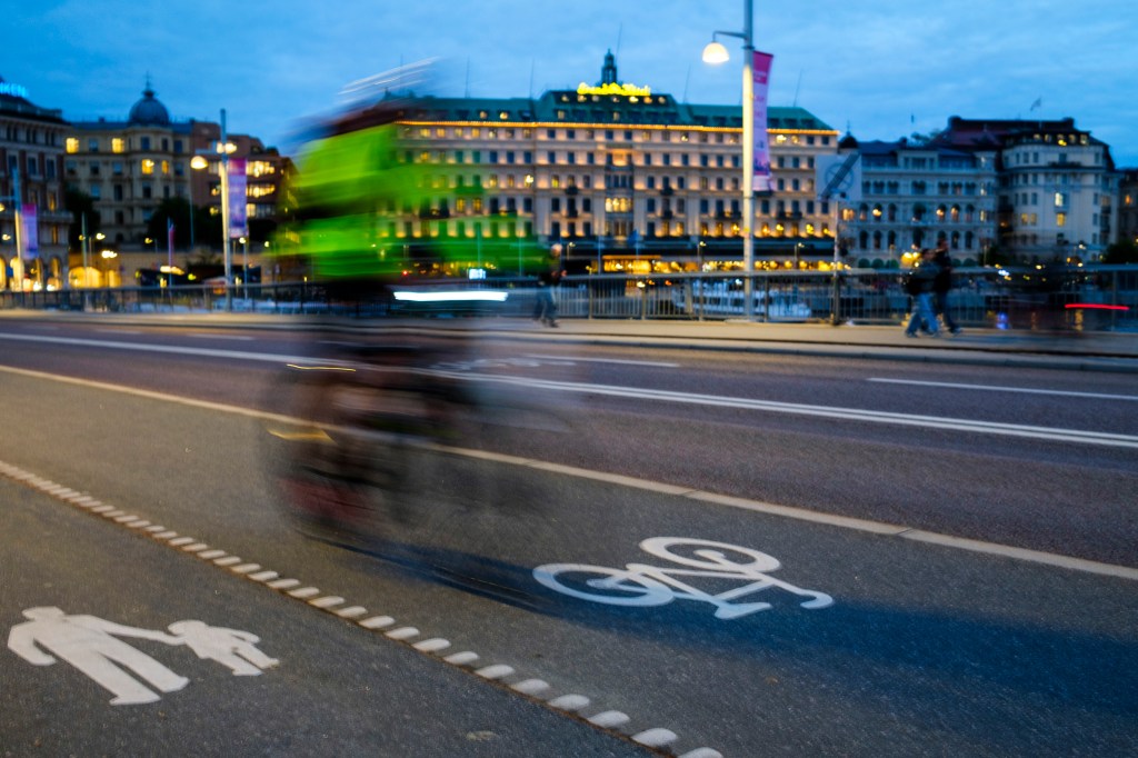 Night view of one cyclist on the bike lane heading towards the historic center of Gamla Stan, on September 16, 2026 in Stockholm, Sweden