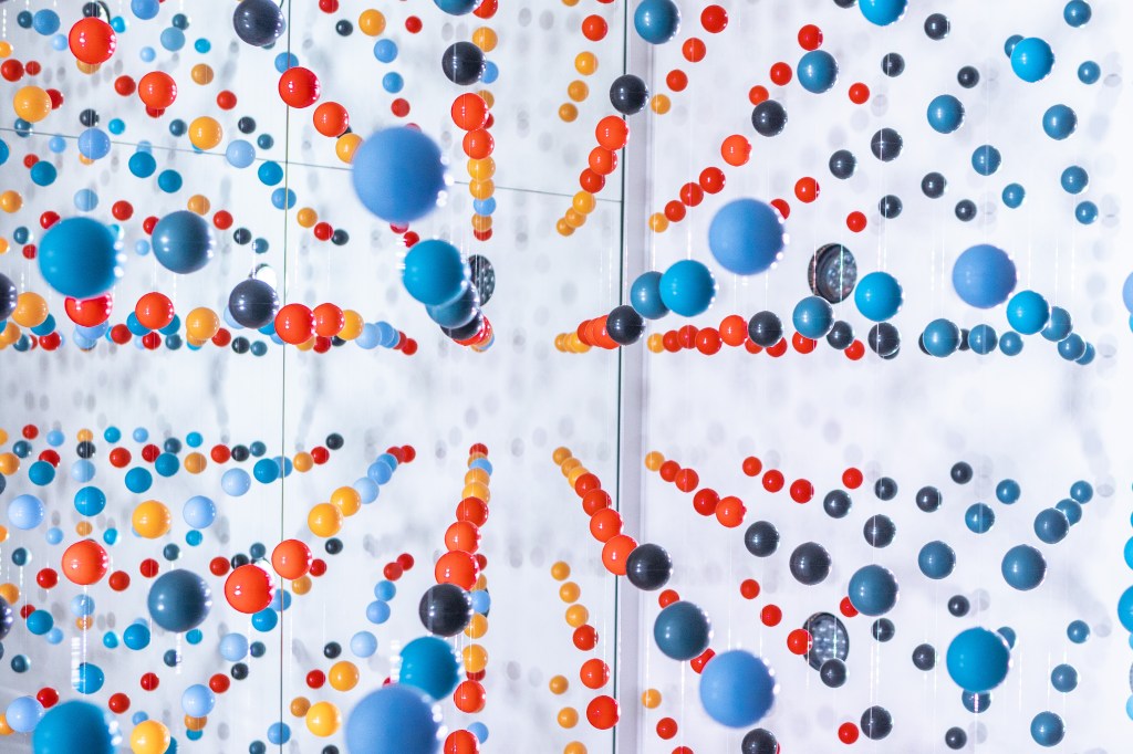 A 3-D photo of many colorful dots or spheres on a white background