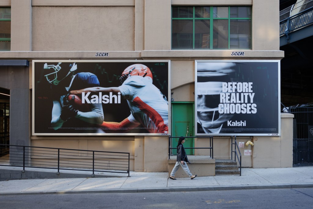 A pedestrian walks past Kalshi advertisements on Adams Street in Brooklyn